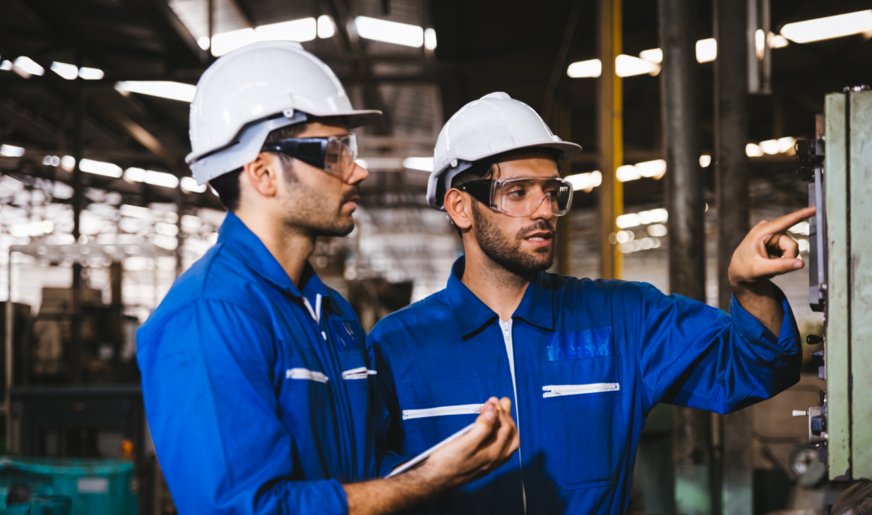 Two male engineers looking at the monitoring screen and discussing