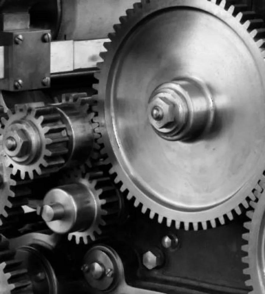 Close-up of meshing steel gears in a machine, in black and white.