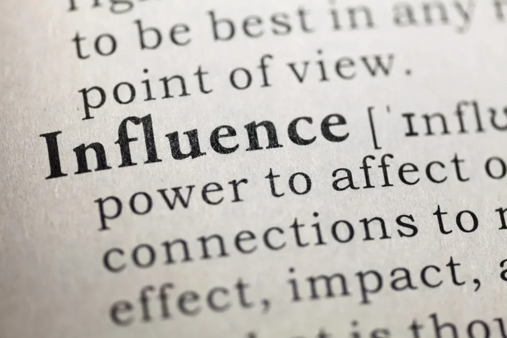Close-up of a dictionary entry for the word 'influence', defined as the power to affect, with the words connections, effect and impact visible.