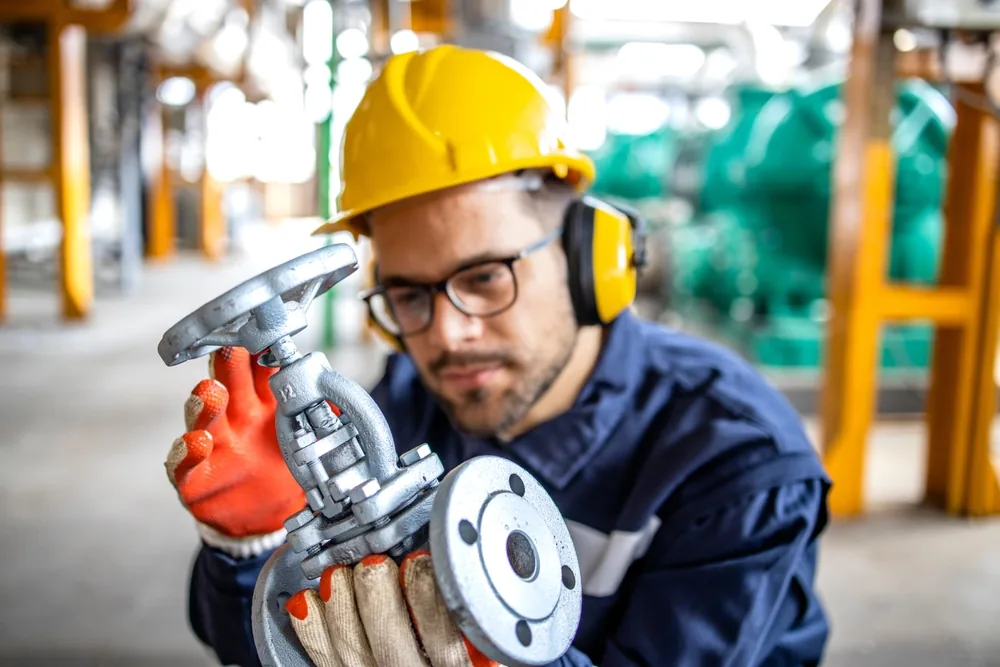 Practical Industry 4.0: Just Do One Thing! A plant staff holding a valve in his hands to check it