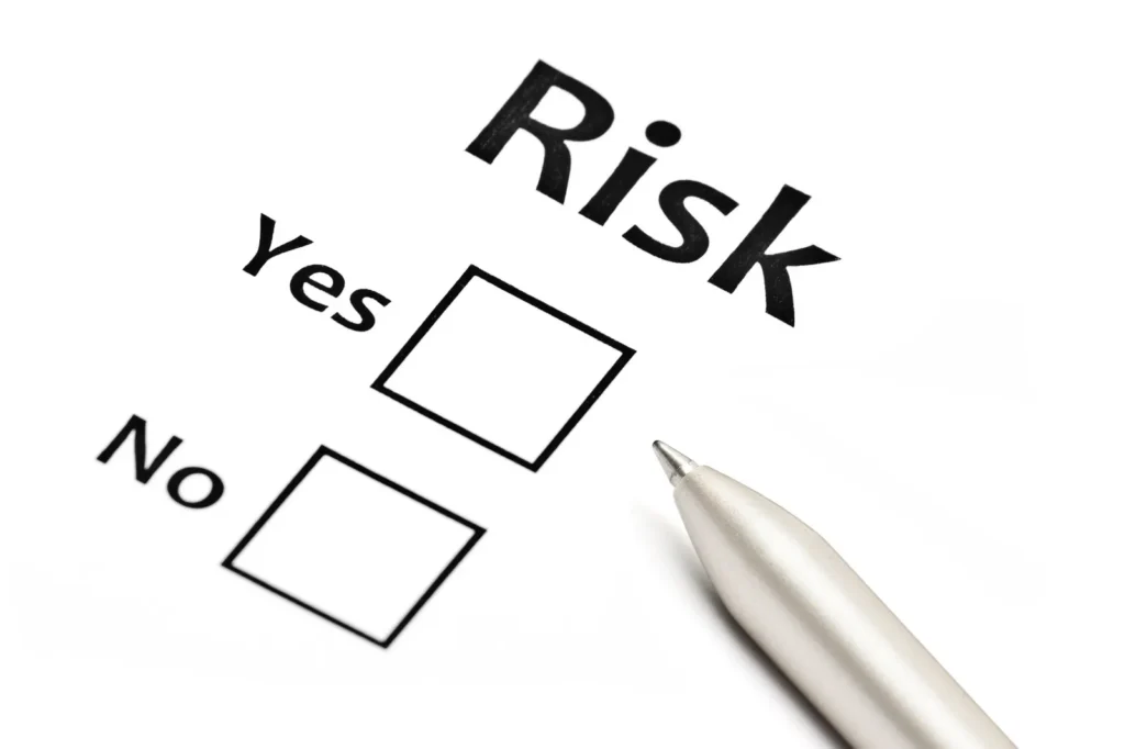 Risk assessment illustration: a pen poised over yes and no tick boxes beneath the word Risk.