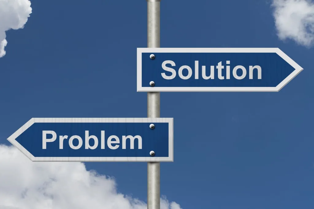 Two signposts against a blue sky, one pointing right to Solution and one pointing left to Problem.