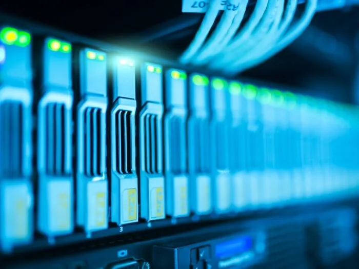Close-up of network switches in a data centre rack, with patch cables and status lights.