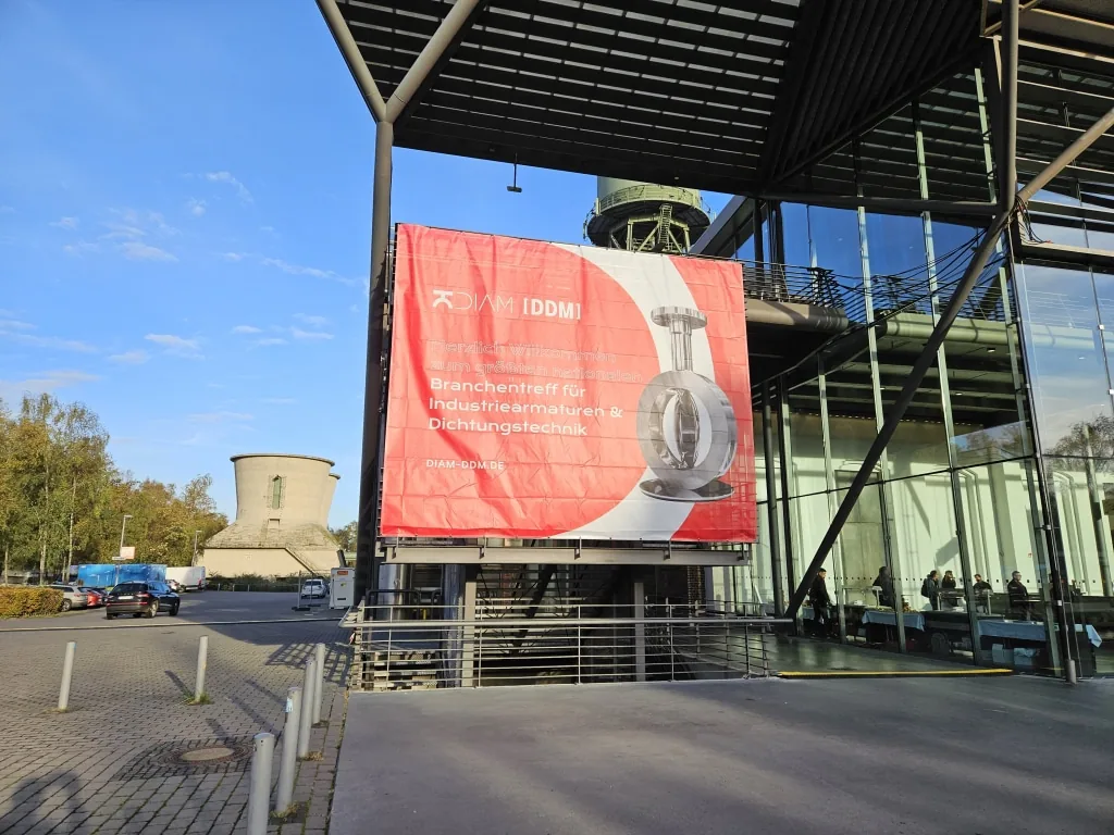 Exterior of the DIAM and DDM trade fair venue in Bochum, with a large red banner advertising the industrial valves and sealing technology event.