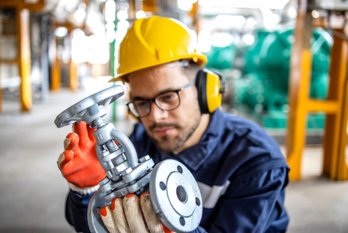 A plant staff holding a valve in his hands to check it